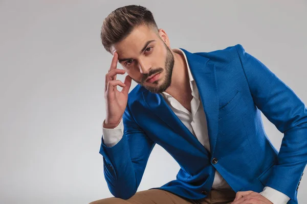 Sexy Smart Casual Muž Myšlení Zatímco Sedí Světle Šedém Pozadí — Stock fotografie