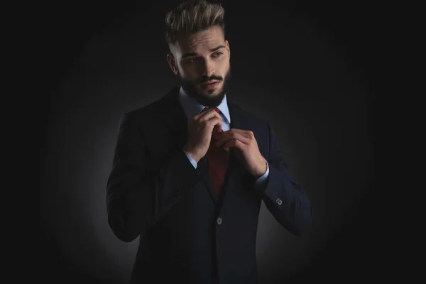 Retrato Empresário Bonito Arranjando Gravata Vermelha Olhando Para Lado Enquanto — Fotografia de Stock