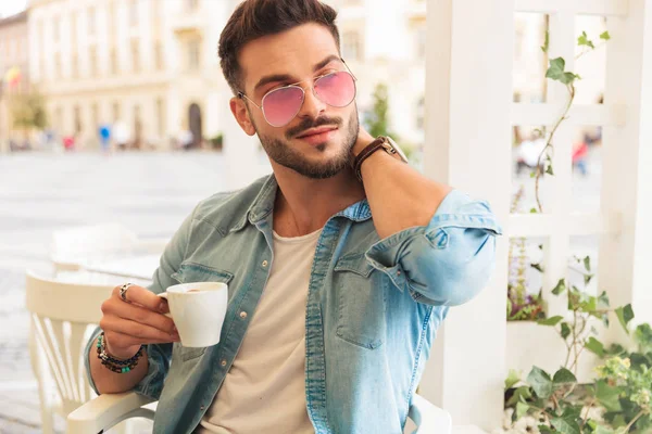 Relaxed Man Drinking Coffee Touching Neck Looks Side While Sitting — Stock Photo, Image