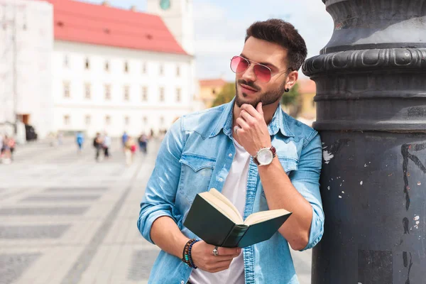 Zvědavec Příležitostné Čtení Městě Myšlení Vypadá Straně Opřený Osvětlovací Stožár — Stock fotografie