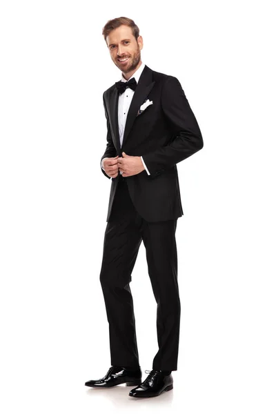 全身画像白い背景の上に立っている間彼の黒のスーツを Unbuttoning 青年実業家 — ストック写真