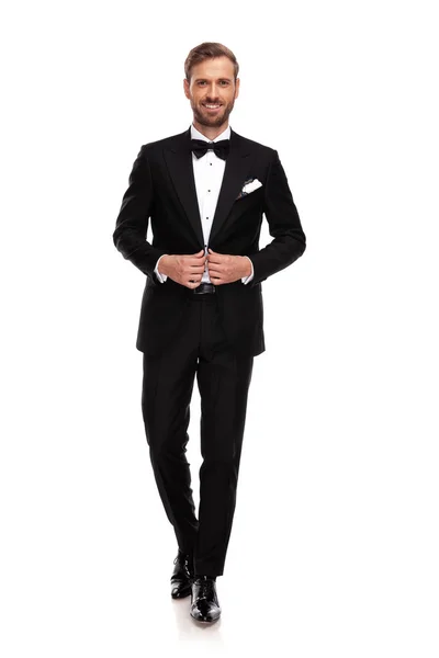 白い背景に前進しながら彼の黒いスーツをボタン青年実業家 — ストック写真