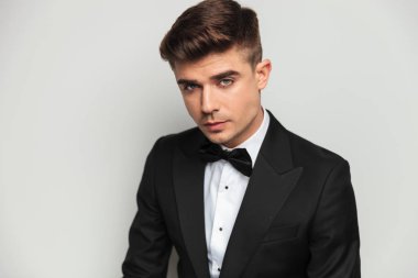 ışık gri arka plan üzerinde duran genç ve yakışıklı damat portresi