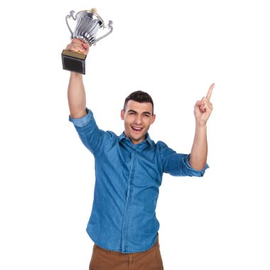 casual adam Kupası havada tutan kutluyor ve puan parmak duran beyaz zemin üzerine, portre resim