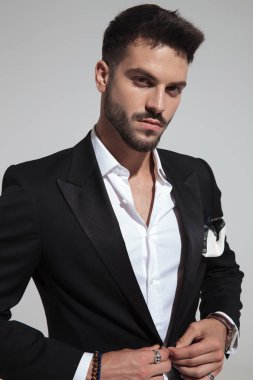 duran ışık gri arka plan üzerinde siyah takım elbise kadar düğmelerini yakışıklı moda adam portresi