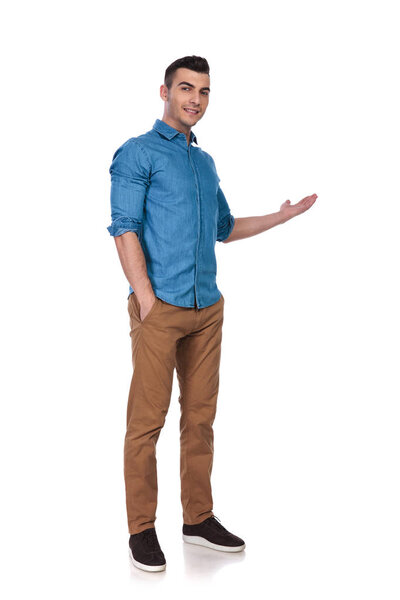 relaxed casual man standing on white background and presenting to side, full body picture