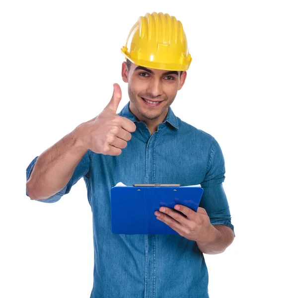 Casual Man Wearing Safety Helmet Makes Thumbs Sign Holds Papers — Stock Photo, Image