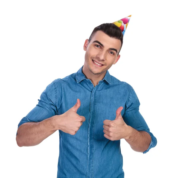 Young Casual Man Wearing Birthday Hat Makes Sign While Standing — Stock Photo, Image