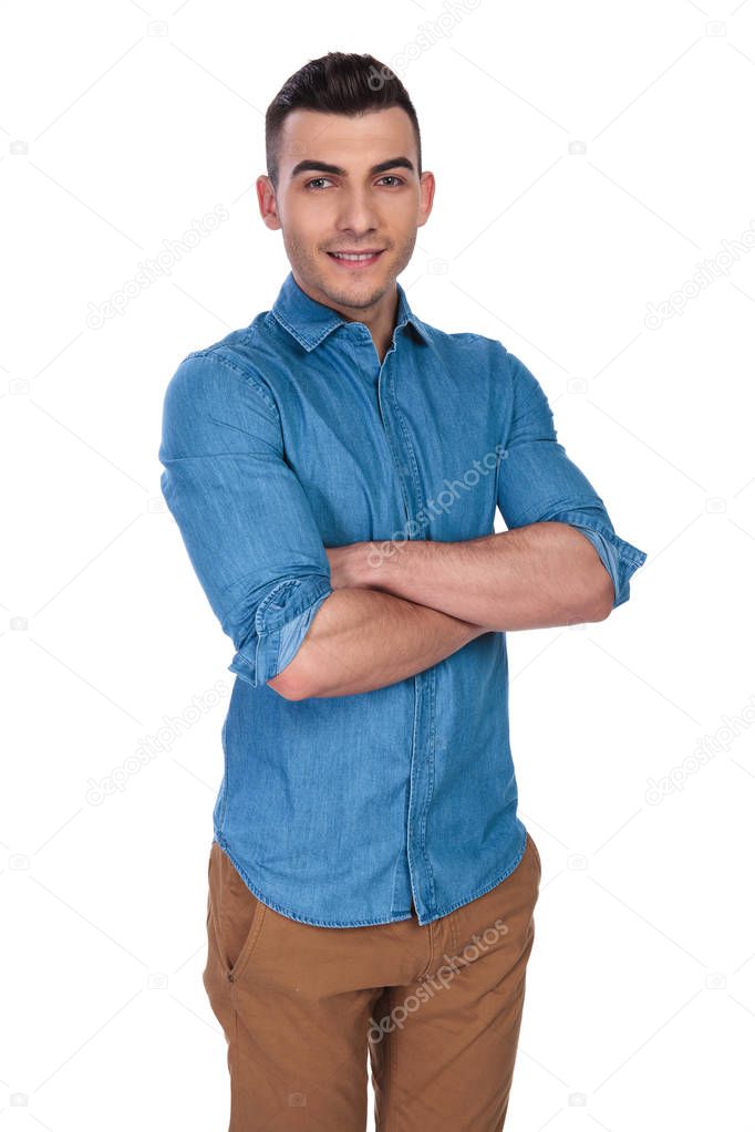 portrait of confident casual man standing with arms folded on white background