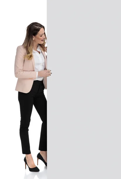 惊讶的女商人拿着大空白板 一边站在白色的背景 全身的画面看着一边 — 图库照片