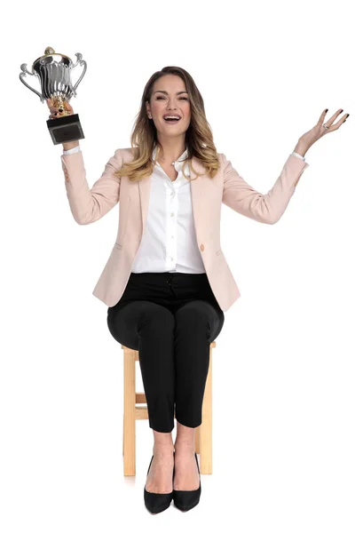 Happy Businesswoman Pink Suit Sits Wooden Chair Holds Trophy Air — Stock Photo, Image