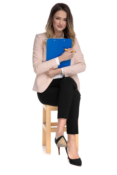 Young Businesswoman Pink Suit Holds Blue Clipboard Pen While Sitting — Stock Photo, Image