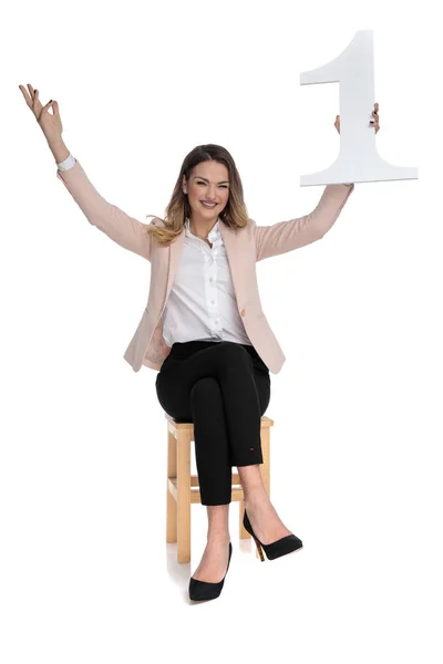女商人坐在椅子上的白色背景 并庆祝第一的手在空中的第一 — 图库照片