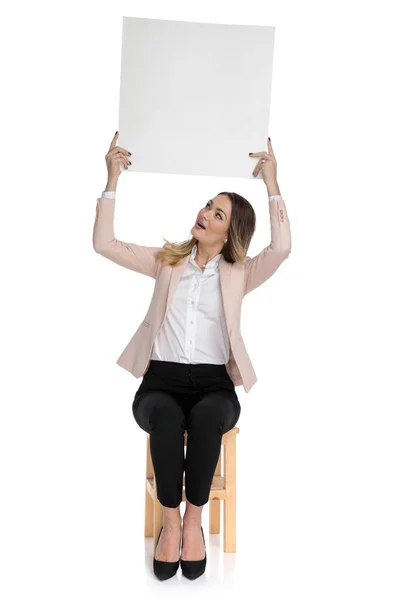 Mulher Negócios Sentada Terno Rosa Detém Placa Anúncio Olha Para — Fotografia de Stock