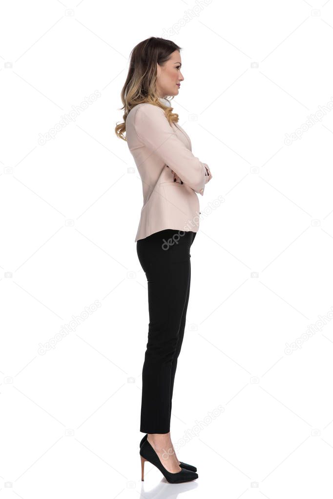side view of confident businesswoman wearing high heels while standing on white background and waiting in line, full body picture