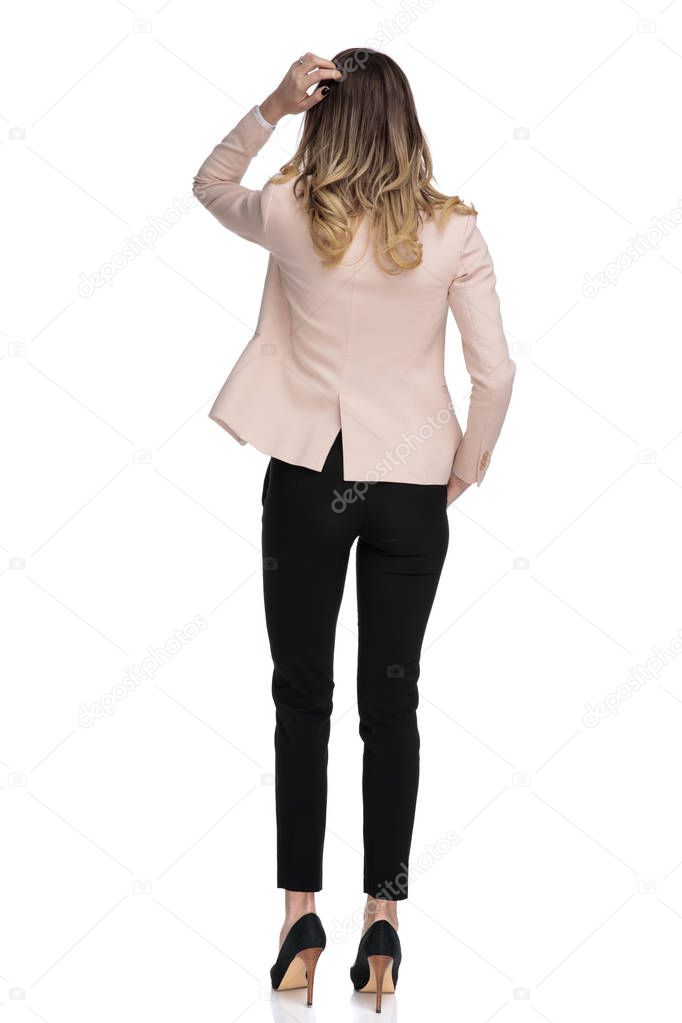 rear view of relaxed businesswoman thinking while standing on white background, full body picture