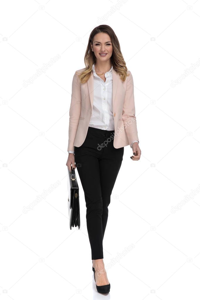 attractive businesswoman holding briefcase and wearing high heels walks forward on white background, full body picture