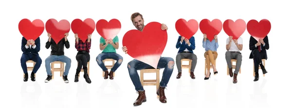 Animado Jovem Casual Homem Mostrando Grande Coração Vermelho Enquanto Sentado — Fotografia de Stock