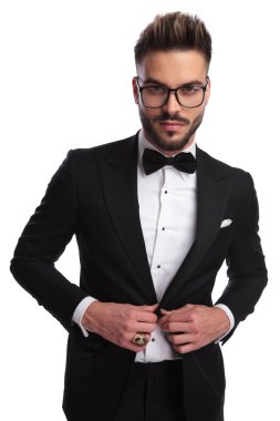 İyi giyimli adam buttonning portresi / unbuttonning beyaz bir arka plan ceketini