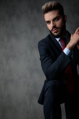 düşünme ve avuç içi birlikte gri studio arka planda tutarak tarafına bakarak ciddi bir genç işadamı portresi