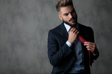 kravat ve uzak görünüyor gri arka plan üzerinde yan çekerek ciddi iş adamı