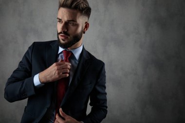 serin genç işadamı kravat ve uzak görünüyor gri arka plan üzerinde sabitleme