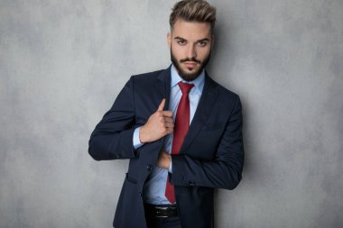 seksi genç işadamı ceketini'nın iç cebinde duran gri duvara arama