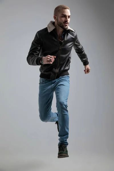 Mann Lederjacke Und Jeans Springt Auf Grauem Hintergrund — Stockfoto