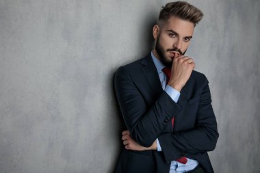 şehvetli genç işadamı düşünme, stüdyo duvara yaslanmış