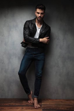 genç adam geçti elleriyle ayakta serin ve çıplak ayakları, stüdyo duvara yaslanmış