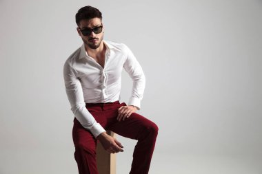 çekici erkek güneş gözlüğü takıyor kameraya doğru ciddi bir göz ile poz veriyor