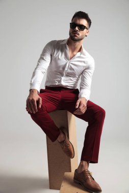 gri arka plan üzerinde poz açılarak gömlek giymiş çekici bir adam portresi