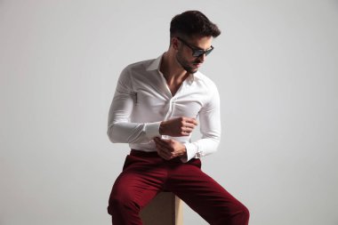 çekici erkek gömlek cebinde gri arka plan üzerine kadar düğmelerini güneş gözlüğü takıyor yan görünüm