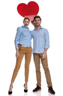 casual birkaç beyaz arka plan üzerinde büyük bir kırmızı kalp onların başının üstünde tutarak