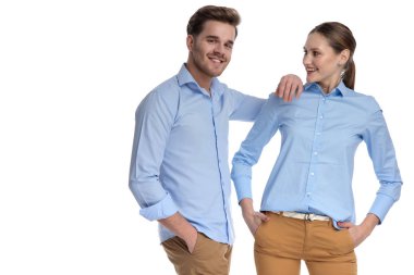 Casual adam gülümseyen dirsek beyaz arka plan üzerinde duran kadının omuz üzerinde eğilir