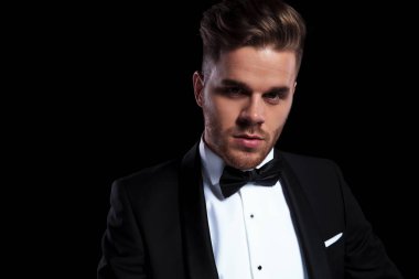 Genç damadın siyah arka plan üzerine kameraya bakarak yakın çekim