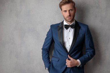 Ceketinin cebinde hafif gri arka plan üzerinde bir el ile kadar düğmelerini Ellegant adam