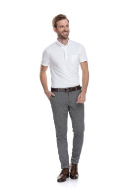 Beyaz arka plan üzerinde dururken yanına rahat gülümseyen smart casual adam görünüyor