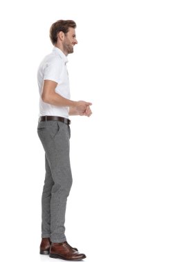 genç adam beyaz arka plan üzerinde biriyle konuşuyor sanki avuç içi ile birlikte ayakta gülümseyen