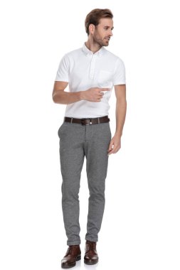 Beyaz arka plan üzerinde uzak kameradan bakarken yan casual adam işaret eden parmağa genç akıllı