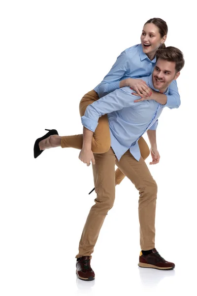 Casual Young Man Carries Woman His Back Both Look Side — Stock Photo, Image