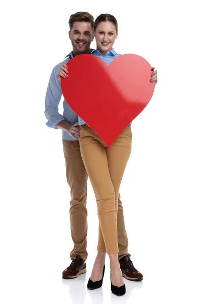 Happy Man Embracing Woman While Both Hold Big Red Heart — Stock Photo, Image