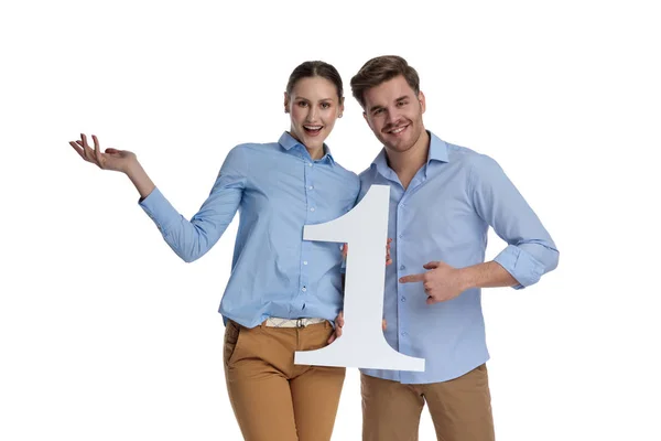 Aufgeregtes Junges Paar Begrüßt Nummer Eins Sein Stehend Auf Weißem — Stockfoto