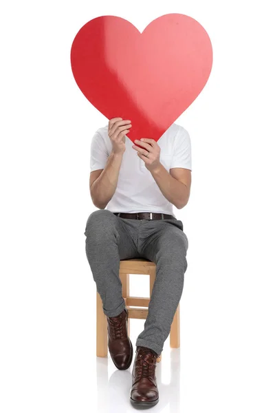 Seduto Uomo Copre Viso Con Grande Cuore Rosso Sfondo Bianco — Foto Stock