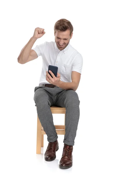 Seated Casual Man Reading Good News His Mobile Phone White — Stock Photo, Image