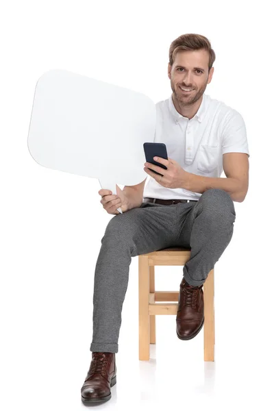 Zittend Casual Man Texting Houden Van Een Tekstballon Witte Achtergrond — Stockfoto