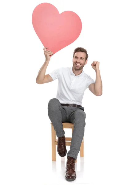 Lächelnder Lässiger Mann Sitzt Und Feiert Den Valentinstag Mit Händen — Stockfoto