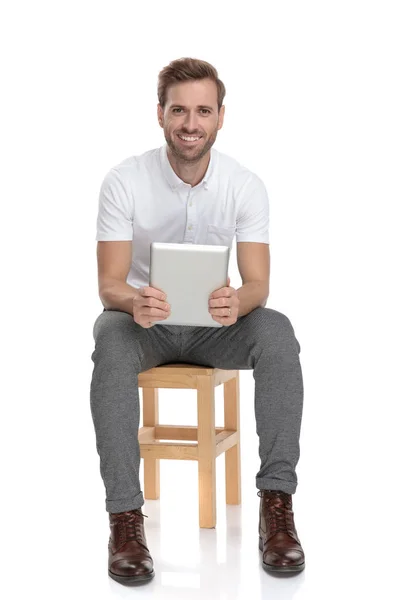Sonriente Hombre Sosteniendo Tableta Sentado Silla Sobre Fondo Blanco —  Fotos de Stock