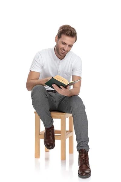 Junger Lächelnder Sitzender Mann Las Ein Buch Auf Weißem Hintergrund — Stockfoto