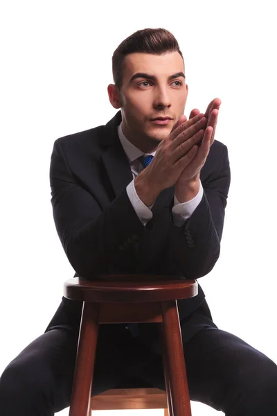 Mann Businessanzug Schaut Beiseite Sitzend Und Betet Mit Den Händen — Stockfoto